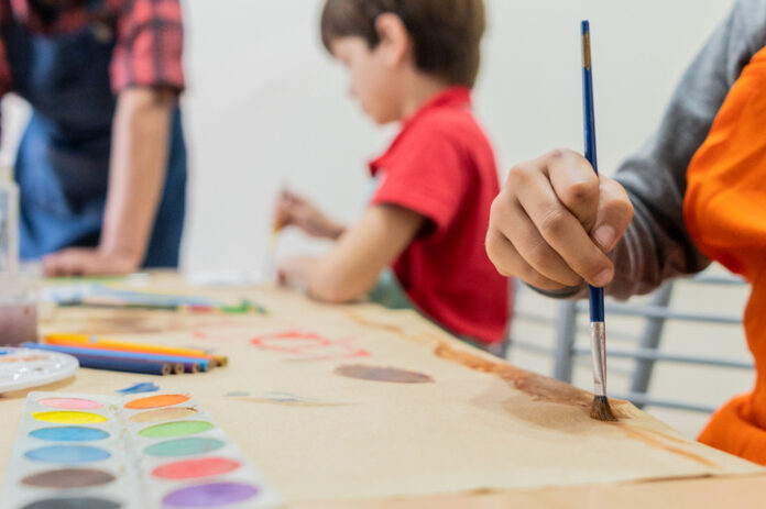 Close-up of a child doing painting activity at school